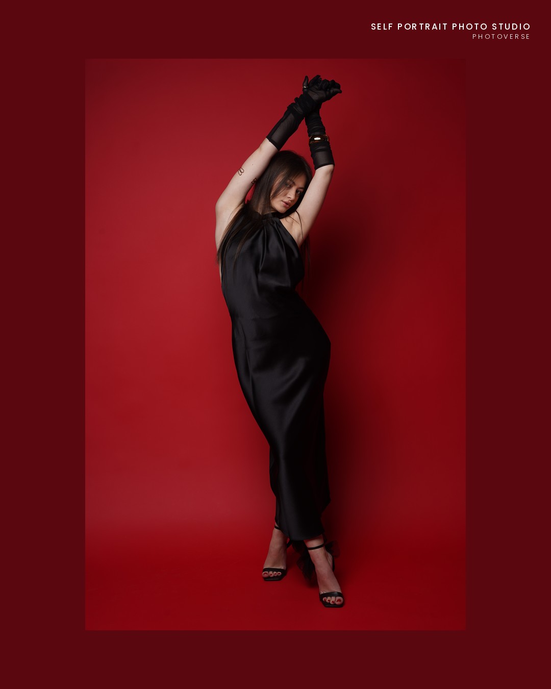 Arms-overhead pose in a black dress, framed print, red backdrop